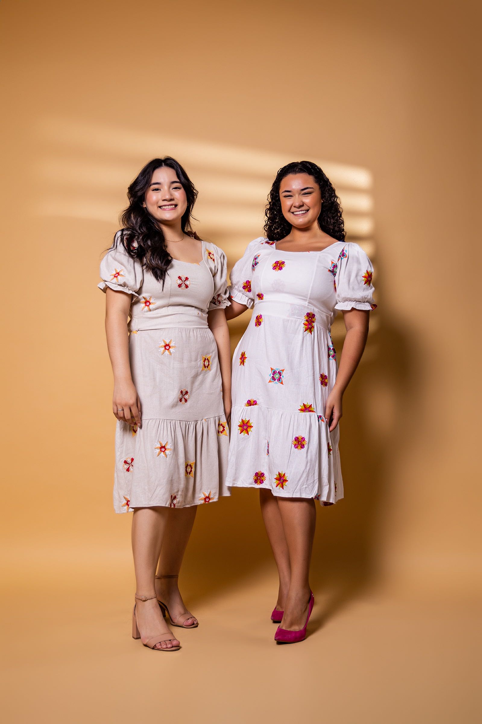 Modelos da Serenna em vestidos florais, fundo dourado