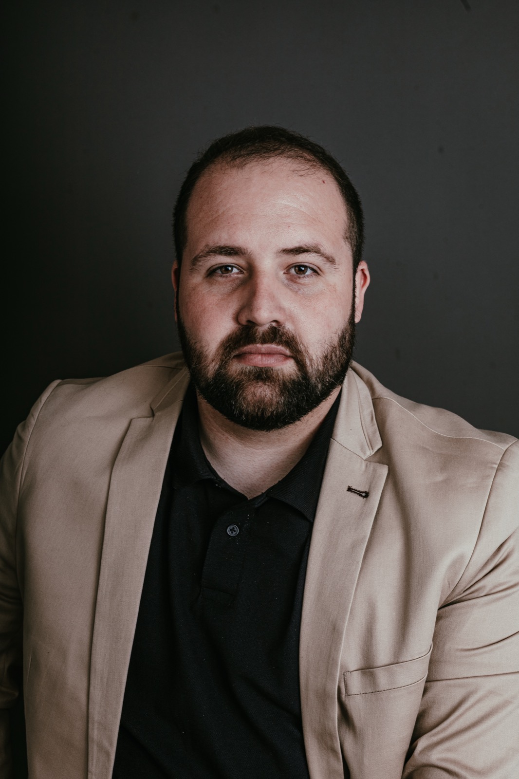 Retrato de blazer bege sobre fundo escuro